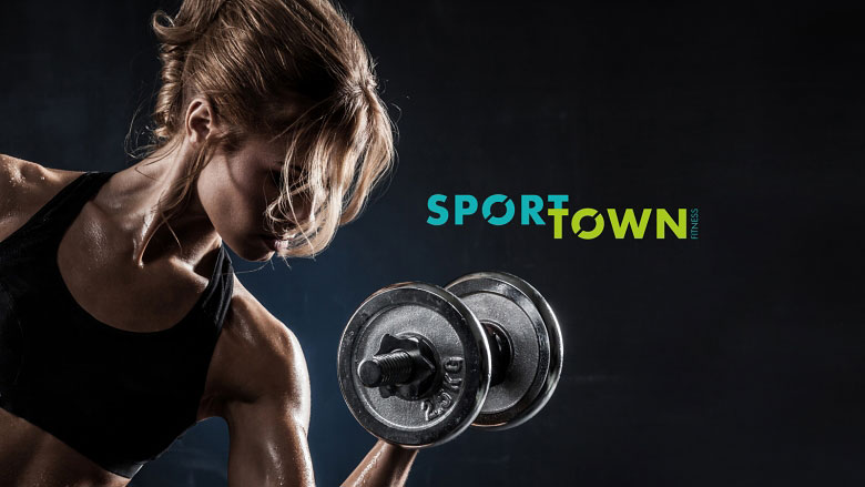 Спортивная девушка с гантелей на фоне надписи SportTown Fitness